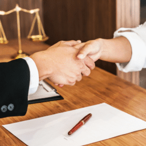 Close-up of a lawyer and client shaking hands over a signed legal agreement, symbolizing trust and successful law firm IT support partnership.