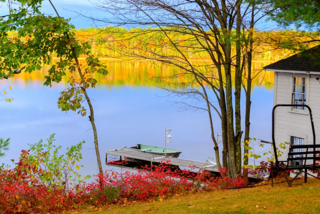 Colorful fall foliage and a quiet lakeside dock in Maine, symbolizing the peace of mind that comes with dependable managed IT solutions.