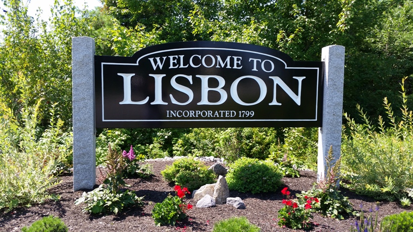 Welcome to Lisbon, Maine” town sign surrounded by landscaped flowers and greenery – a local community embracing reliable managed IT services.