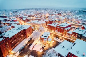 Aerial winter view of a town lit up at dusk, illustrating how managed IT keeps critical infrastructure running smoothly through all seasons.