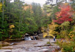 Downtown Bethel, Maine in autumn with colorful trees and a river, reflecting the town’s connection to nature and growing need for managed IT solutions in small communities.