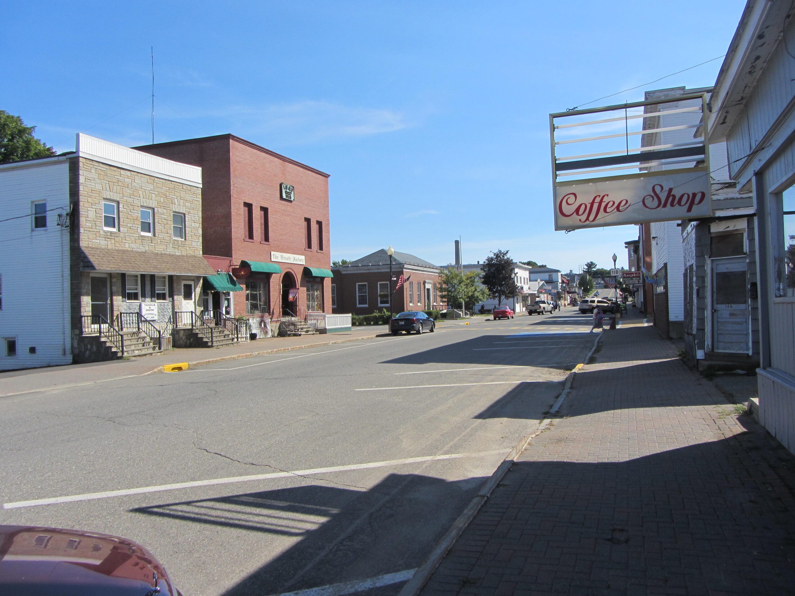 Downtown Millinocket storefronts on a sunny day, where dependable managed IT services help local businesses thrive in Maine’s remote communities.