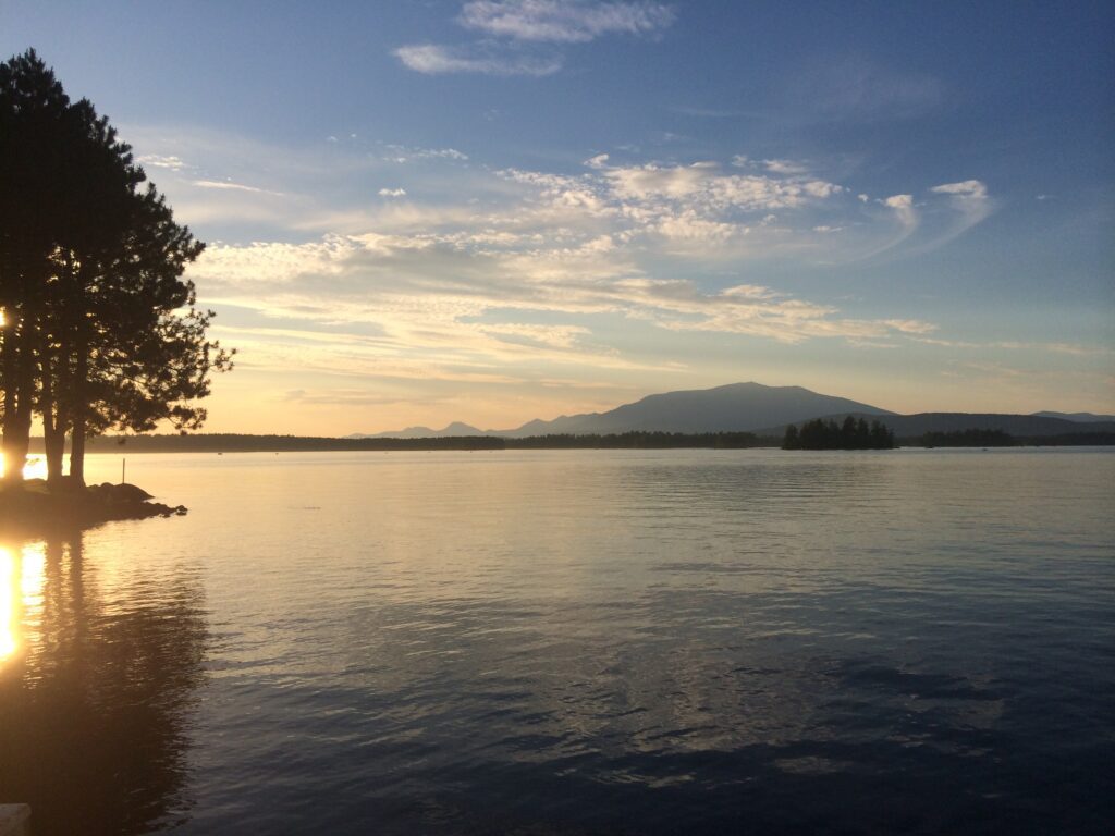 Scenic view of Millinocket Lake at sunset, representing the calm reliability and remote-ready benefits of managed IT services for rural Maine communities.