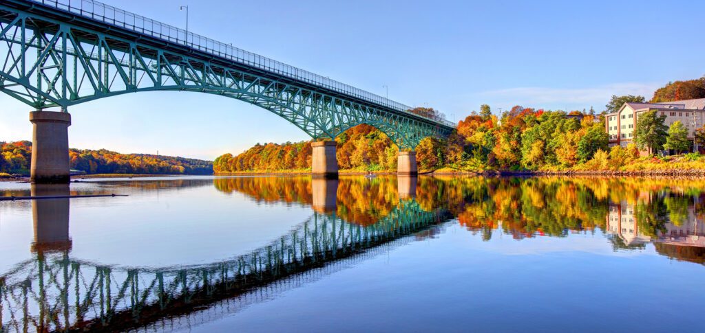 Bridge over calm water in Oakland, Maine, highlighting the town’s connection and growth through dependable managed IT support.