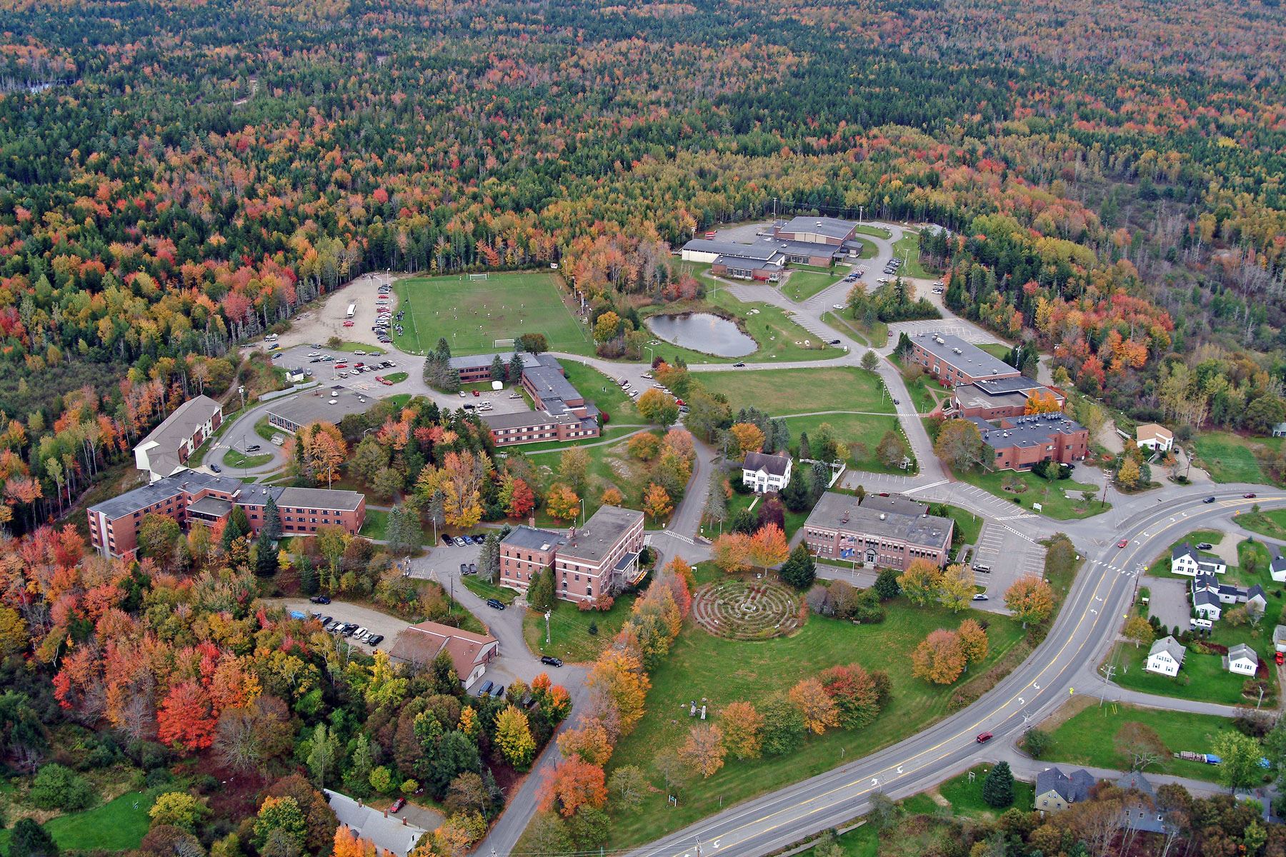 Aerial view of the University of Maine campus in Orono surrounded by fall foliage, representing the importance of managed IT support in educational and municipal systems.