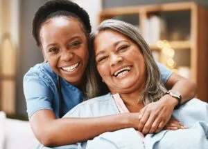 Caregiver embracing senior woman, symbolizing trust in reliable senior living security systems.