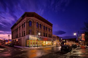 Downtown Rockland, Maine at dusk with historic buildings lit up, representing the reliable backbone local businesses trust—supported by managed IT solutions.