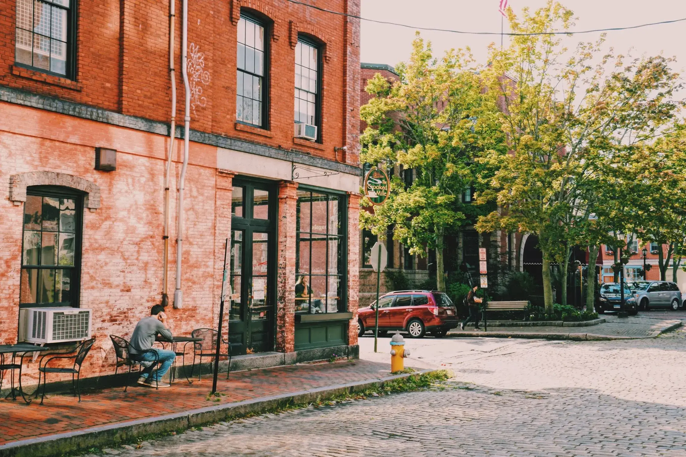 Downtown Biddeford, Maine with red-brick buildings and café seating—reflecting how managed IT helps local businesses thrive in a historic setting.