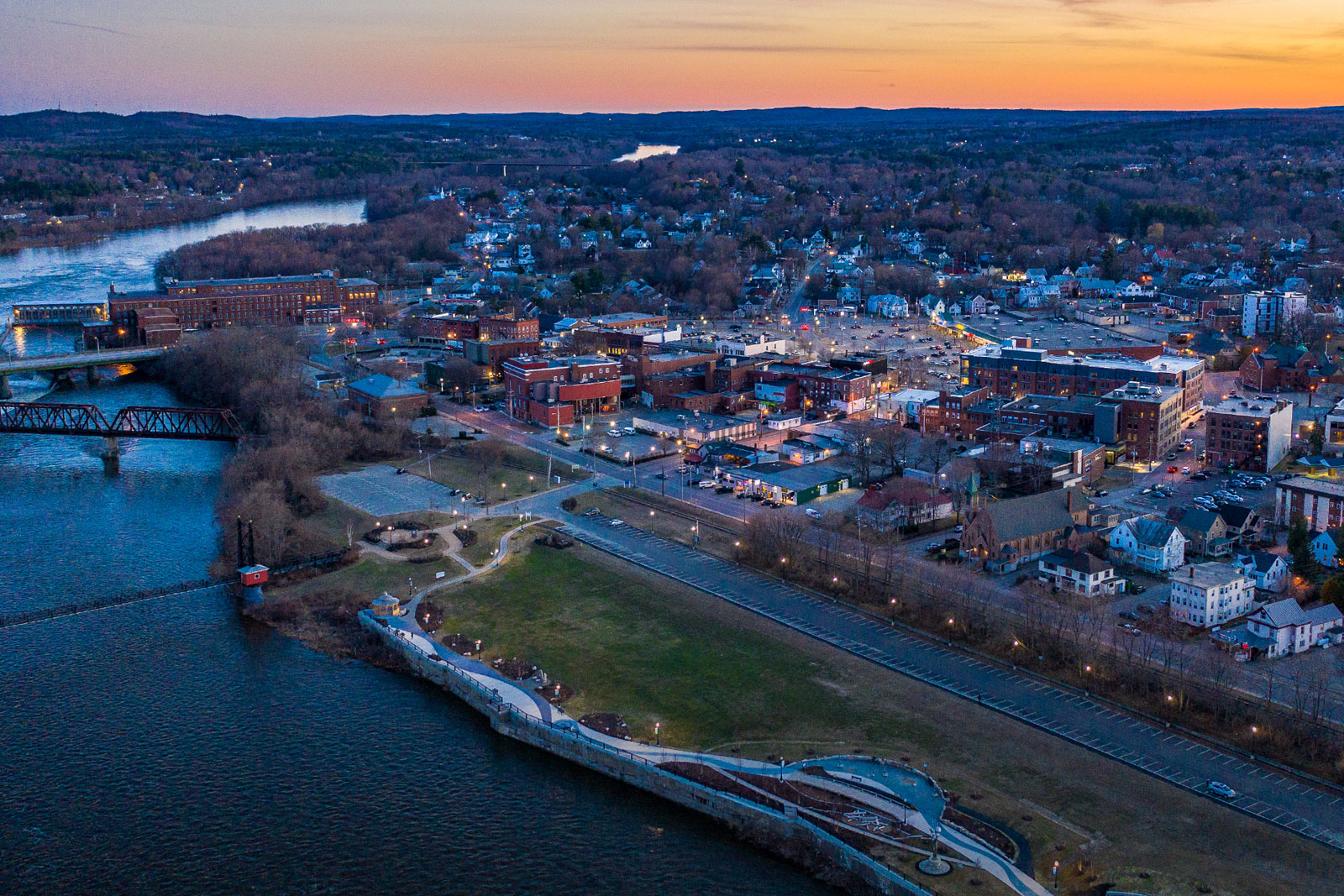Aerial sunset view of Waterville, Maine highlighting the town's downtown district and riverfront, where managed IT services support local government, healthcare, and small businesses.