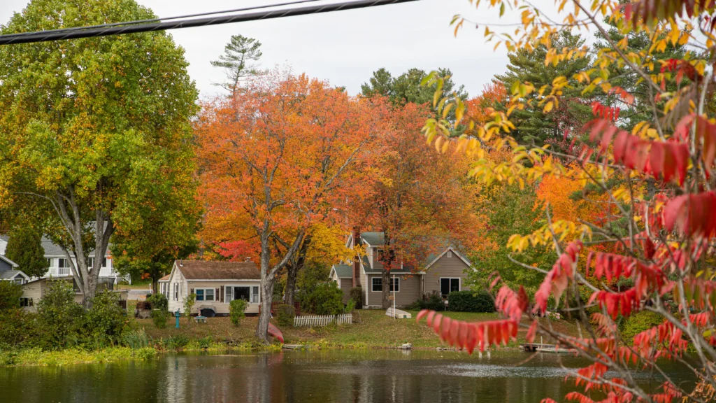 Lakeside homes in Windham, Maine surrounded by vibrant fall foliage, representing a peaceful community supported by reliable managed IT solutions.