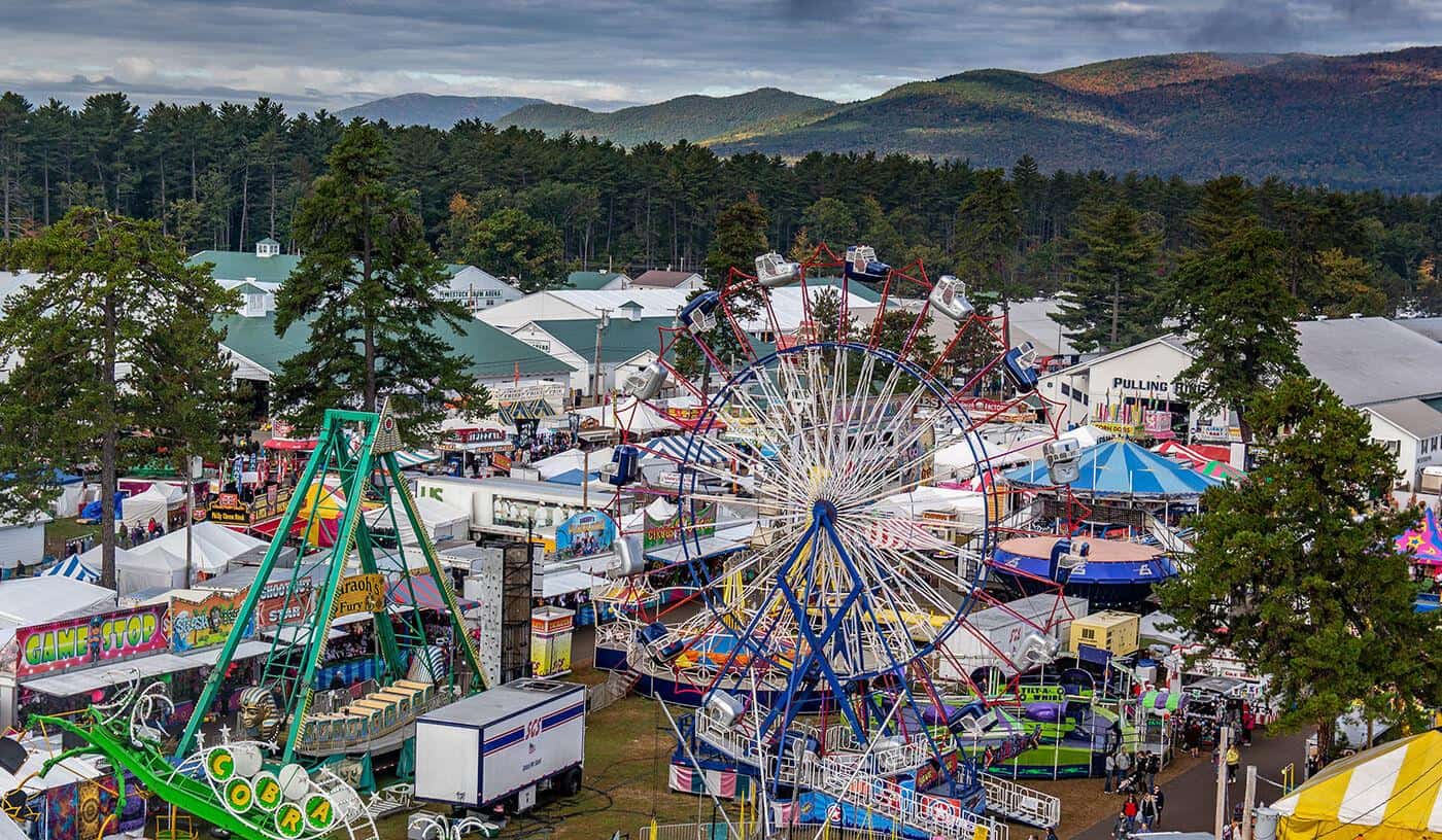 A vibrant fairground scene in Fryeburg, Maine with rides and colorful tents, highlighting the importance of managed IT in supporting large-scale community events and operations.